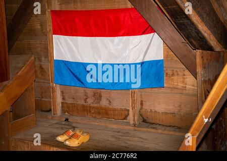 The Netherlands flag hang on a wooden wall with a pair of dutch clogs (Klompem in dutch) inside the United Peoples Windmill (Moinho Povos Unidos). Stock Photo