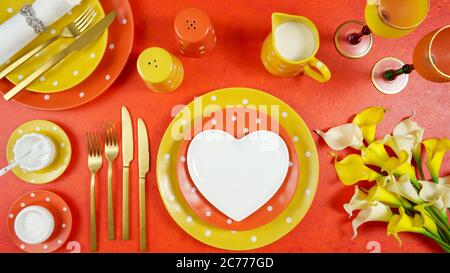 Orange and yellow aesthetic modern events table place setting overhead for weddings, birthdays, Christmas, or Thanksgiving celebrations. Top view crea Stock Photo