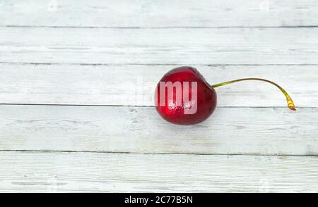 Ripe cherry on a wooden background with water drops. Tasty and healthy food. Stock Photo
