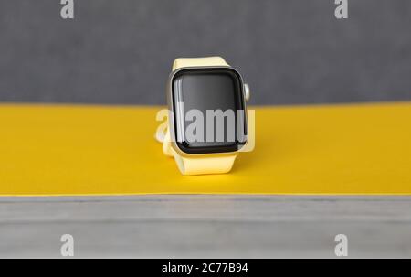 Petrozavodsk, Russia - July 12, 2020: Close-up new Apple Watch Series 4 aluminum and ceramic case. On yellow and grey background. Stock Photo