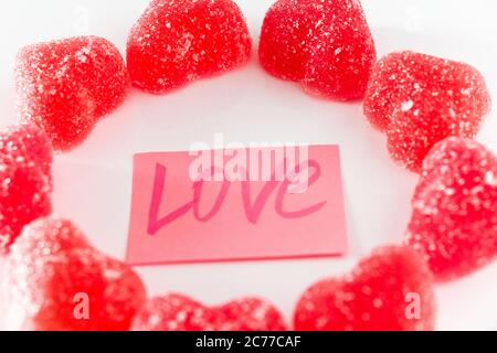 Circle made of sweet red marmalade in the shape of a heart and the word love. Stock Photo