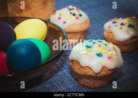 Easter baking - cupcakes with white sweet icing and multi-colored chicken eggs Stock Photo