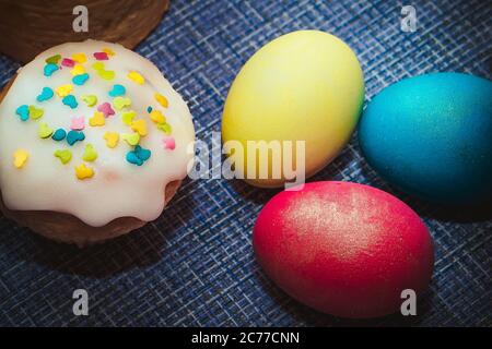 Festive composition - Easter baking and three colored eggs Stock Photo
