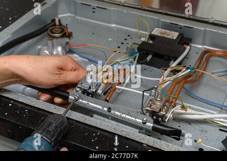 man fixing a gas cooker Stock Photo