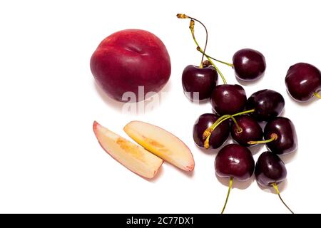 Pieces of nectarine closeup  and ripe sweet cherries isolated on white background Stock Photo