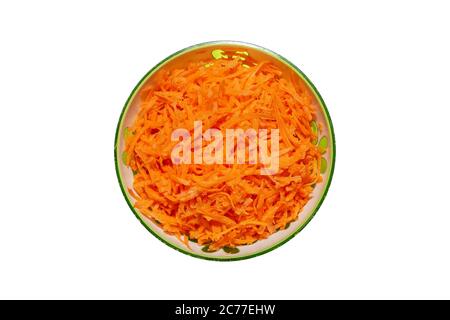 Shredded fresh carrots in a bowl on a white background. Vegetable carrot salad in a green plate. Stock Photo