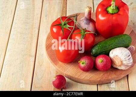 Set of fresh vegetables in a basket on a wooden background. The concept of healthy nutrition and diet. Place for text. Stock Photo