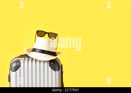 Travel bag, Luggage, Straw hat and sunglasses on yellow background with copy space. suitcase, hat , black sunglasses isolated on yellow background. Su Stock Photo