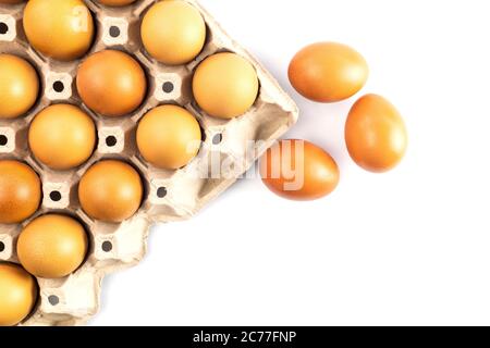 Top view chicken fresh eggs in cardboard egg box holder and 3 fresh eggs outside isolated on white background. Stock Photo