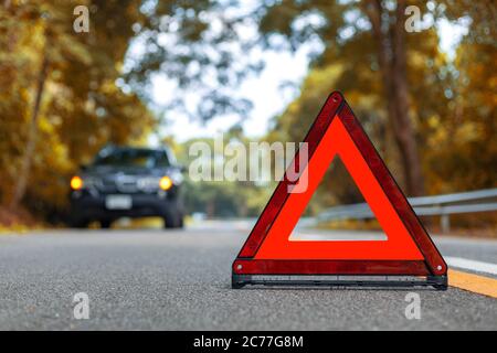 Black car have accident park on road. Red triangle, red emergency stop sign, red emergency symbol and black car stop and park on road. Stock Photo