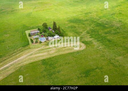 aerial landscape with farm house, equipment and warehouses among green fields. birds eyes view Stock Photo