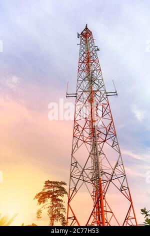 mobile phone communication and network signal repeater antenna tower with blue sky background. Sun light effect. Stock Photo