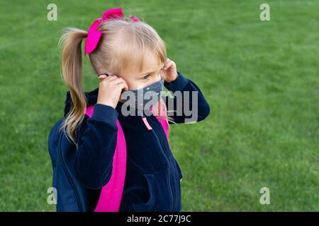 Young student caucasian girl wearing protective cotton mask for school. Return back to school, reopening, new life. Stock Photo