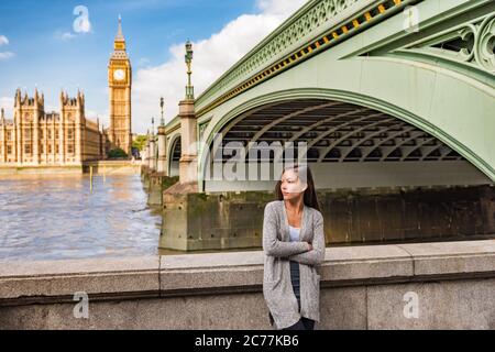 London city lifestyle casual young Asian woman relaxing by the Thames River by Big Ben, UK, Europe. Stock Photo