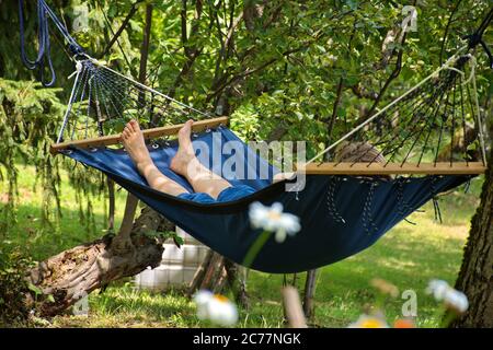 Woman relaxing in hammock during summer holidays Stock Photo
