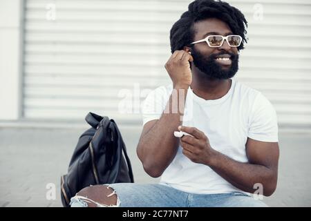 portrait of a handsome happy black man with wireless headphones Stock Photo