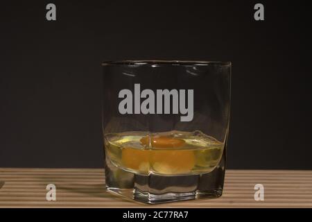 Raw egg in a glass beaker. On a black background Stock Photo