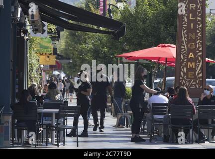Burlingame, United States. 15th July, 2020. Masked and gloved staff wait on customers seated on the sidewalk outside Limon Rotisserie in Burlingame, California on Tuesday, July 14, 2020. California's Governor Gavin Newsom has ordered a rollback in openings and an end to inside dining amid a spike in COVID-19 cases across the state. Photo by Terry Schmitt/UPI Credit: UPI/Alamy Live News Stock Photo