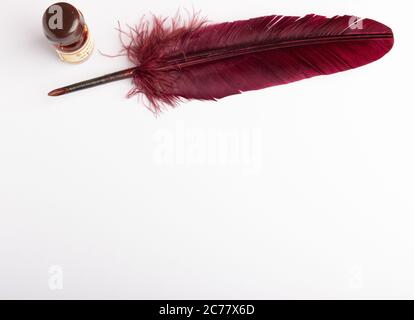 feather quill and inkwell on a white paper with copy space Stock Photo