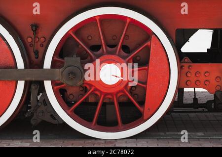 Red white wheel of vintage steam locomotive with connecting rod, close-up photo, front view Stock Photo