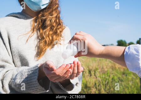 Social distance. Sharing disinfectant gel. Mother and daughter in social distancing. Washing their hands. Pandemic. Alcohol disinfectant. Coronavirus. Stock Photo