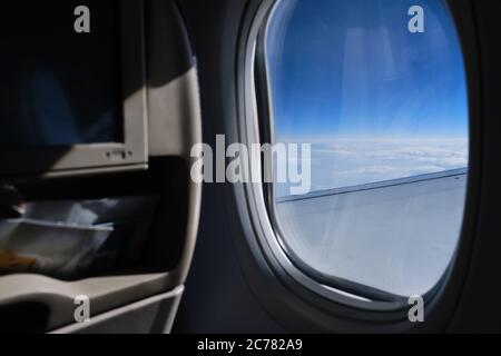 Porthole sky view. Commercial airplane window view from passenger seat Stock Photo