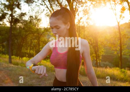Woman checking her fitness watch and health tracking wearable device Stock Photo