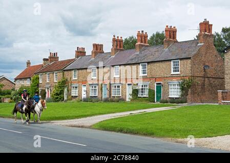 Horse riders in the village of Sutton on the Forest, Hambleton, North Yorkshire, England UK Stock Photo