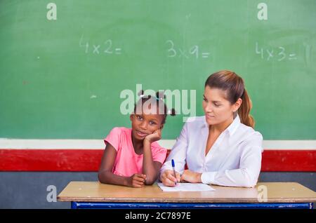 School teacher interviewing pupil at chalkboard. Back to school concept.. Stock Photo
