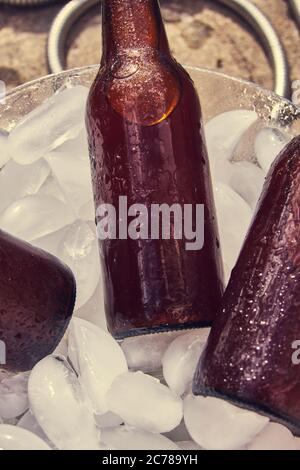 beer bottles with drops on ice cubes, brown bottles Stock Photo
