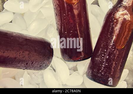 beer bottles with drops on ice cubes, brown bottles Stock Photo