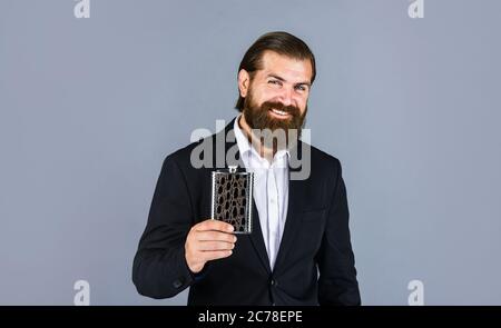 really good taste. Flat metal bottle for alcohol. man with elegant look. bearded hipster in suit hold metal flask for alcohol. Alcohol drink concept. Have alcohol drink with you. Always with me. Stock Photo