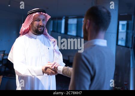 Arab Businessmen's Handshake with American Businessman Descent. Confirmation of Business alliance Partners as WELL. Adhering Respect, Commitment and I Stock Photo