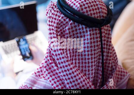 Middle Eastern businessman talking on the phone and looking out the window in his office. Businessman Arabic using mobile phone for connection to comm Stock Photo
