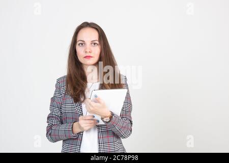 Portrait of a young woman with beautiful eyes in a business suit and a tablet in her hands Stock Photo