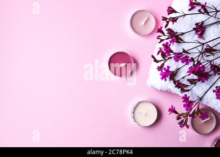 White Cotton Towel With Small Pink Flowers And Aroma Candles On Pink 