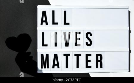 ALL LIVES MATTER text with deep shadows of heart on a black and white background. Protest against the end of racism, anti-racism, equality Stock Photo