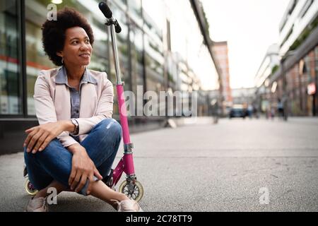 Beautiful woman riding an electric scooter to work, electric transport, ecological transport Stock Photo