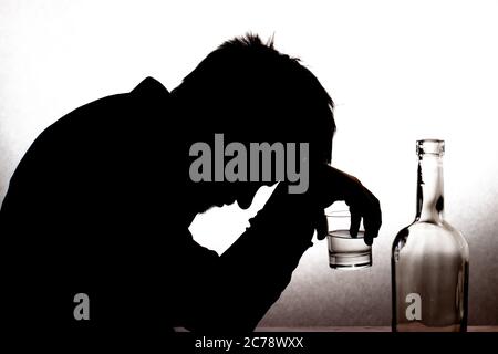 A man and a glass of vodka. Alcoholism, alcohol addiction, delirium tremens. Stock Photo