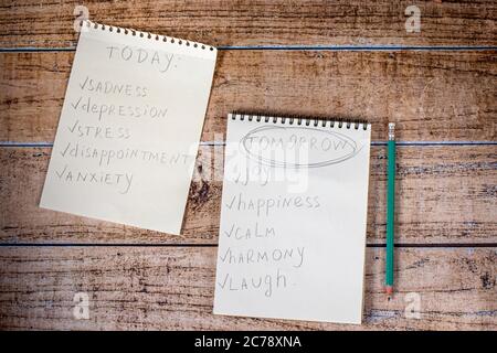 Notepad and green pencil on a wooden background. Motivational quotes and success in the future, achieving the goal and happiness. Stock Photo