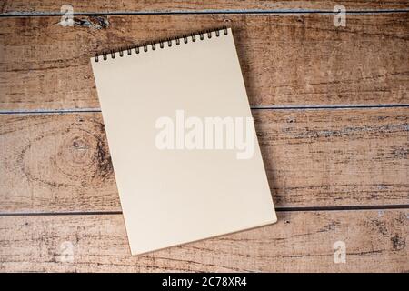 White sheet page notepad on a wooden brown background. A pad on a spiral, a place for notes. Stock Photo