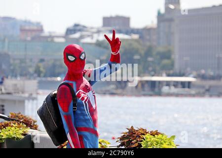 Person in Spider-man costume shows the victory sign on Moscow river embankment. Cosplayer in a summer city, entertainment and hobby Stock Photo