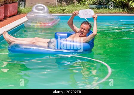 A white man on an inflatable mattress in a swimming pool holds the S.O.S. to ask for help Stock Photo