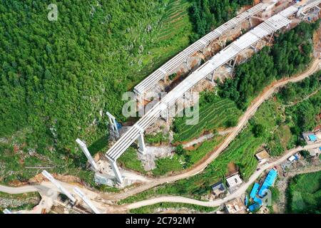 Weining. 15th July, 2020. Aerial photo taken on July 15, 2020 shows the construction site of the Weining-Weizhang expressway in Weining, southwest China's Guizhou Province. The Mezhan tunnel of the Weining-Weizhang expressway, located in Mezhan Town of Weining County, was dug through on Wednesday, as construction of the 28 km-long expressway, with a designed speed of 80 kph, has proceeded smoothly. Credit: Liu Xu/Xinhua/Alamy Live News Stock Photo