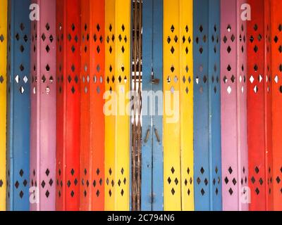 Front view of a colorful collapsible metal door used by shophouses in the heritage enclave of Penang Stock Photo