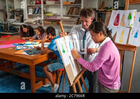 School Art Class fashion design with teacher and teenage girl pupil working on her fashion design clothing project drawings in school art classroom Stock Photo