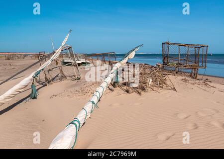 Rolled boat sails and traps to catch lobsters at Ponta Grossa Beach, Icapui, Ceara, Brazil Stock Photo
