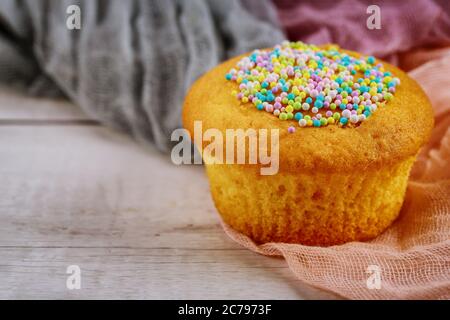 Birthday vanilla cupcake with sugar sprinkles. Close up. Stock Photo