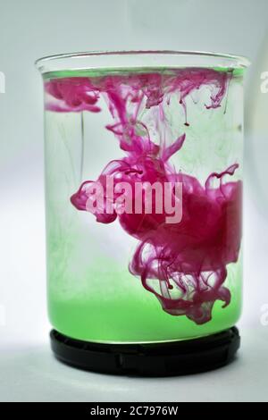 A closeup photograph of Pink and Green color mixed in water. Stock Photo