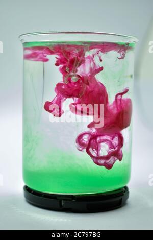 A closeup photograph of Pink and Green color mixed in water. Stock Photo